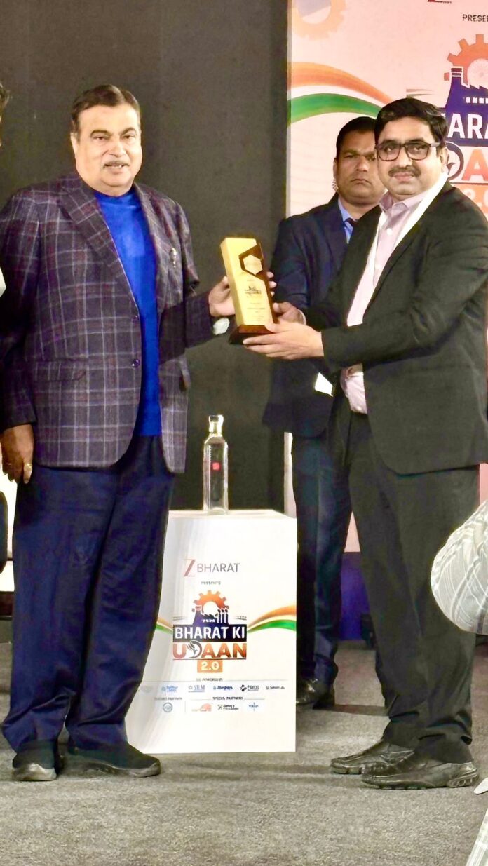 Nitin Gadkari presents the Excellence in Renewable Energy Award to Joint Solar Director Vinod Sharma in New Delhi.
