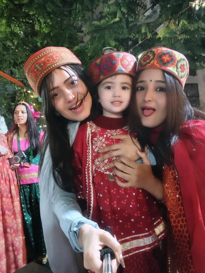 Smiles, laughter and cultural joy as girls share playful moments with children during the Uttarakhand Vasantotsav celebrations at 11th Avenue, Gaur City-2.