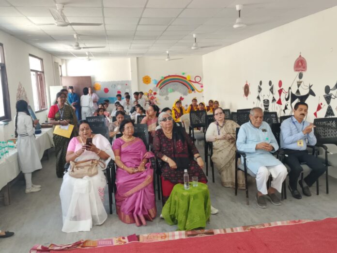 Reva Nair being welcomed with a pearl garland and a painting made by students at Sanskar Adhyayan Kendra, Noida.
