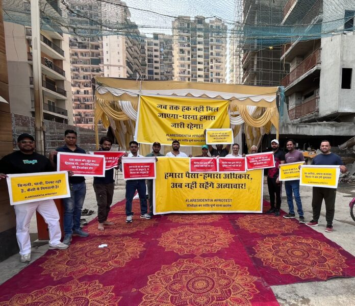 Residents of La Residentia stage a peaceful sit-in protest near the builder’s sales office, raising concerns over incomplete construction, poor basic facilities and long-pending issues in the society.