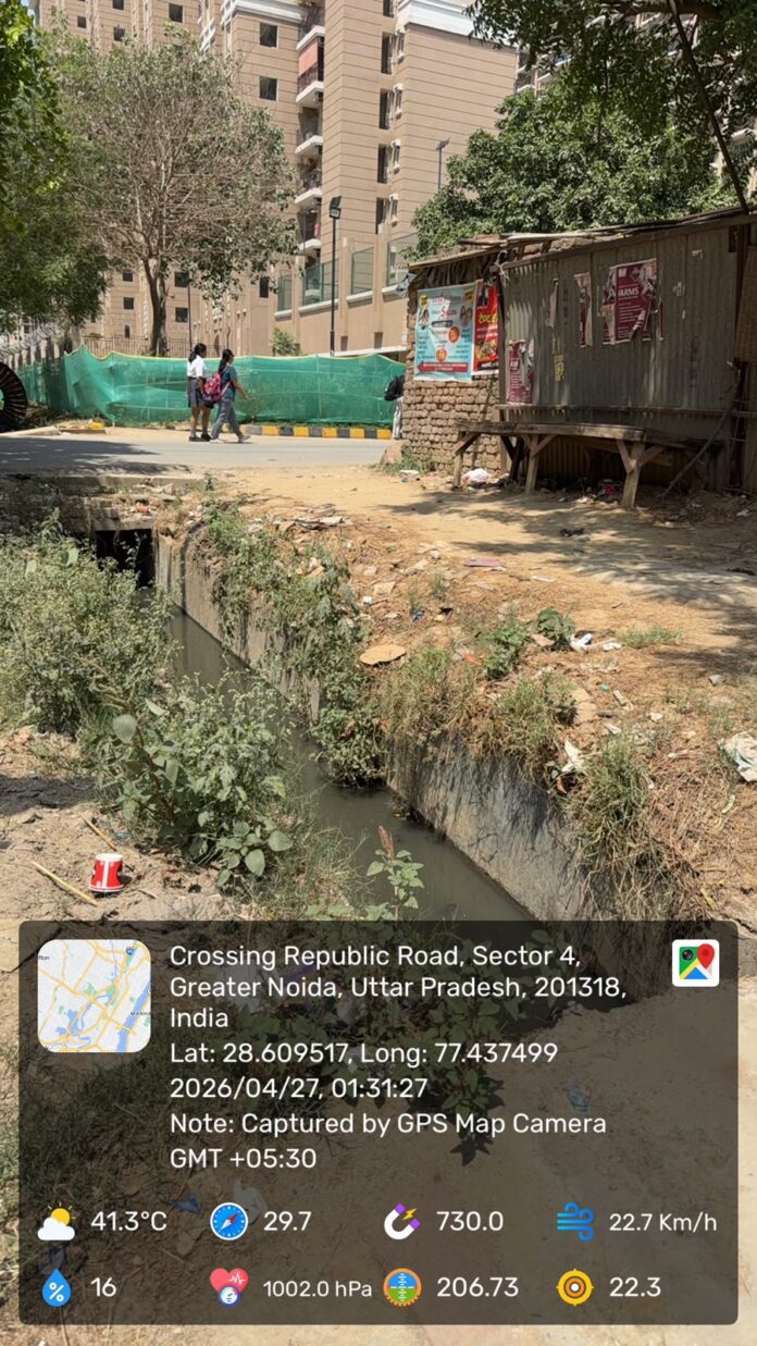 Residents demand a covered drain and pedestrian footpath along the Iteda Gol Chakkar–Shahberi road near ATS Homekraft Nobility amid ongoing road widening work
