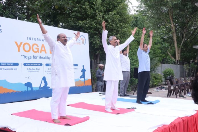 Residents participate in a large-scale yoga session during the International Yoga Day celebration organized by RWA Sector 105 and Yatharth Hospital in Noida on June 21, 2026.