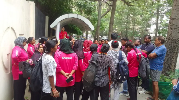 Domestic workers gather outside a residential society in Greater Noida West to protest an alleged assault on a fellow worker, highlighting concerns over safety and dignity in the domestic services sector.