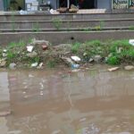 Children and parents struggle to cross the waterlogged Casa Greens 1 side service road, where rainwater mixed with foul-smelling STP discharge has turned the route into a hazardous stretch.